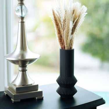 ZEPHYR black vases with pampas grass on a side table. This is a black vase next to a lamp.