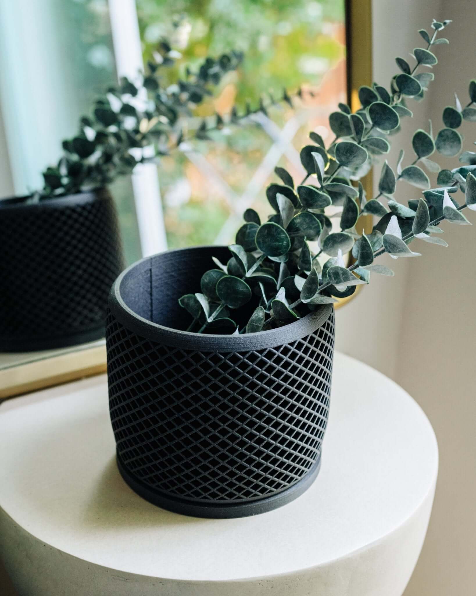 Black modern plant pot by Woodland Pulse with eucalyptus.