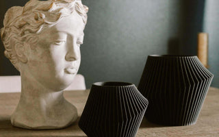 Two black planter pots by Woodland Pulse. These are modern indoor planters.