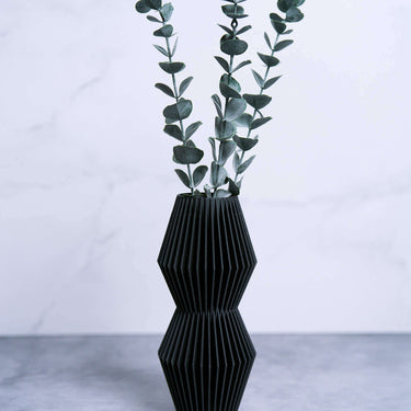 A black vase with eucalyptus. This is a modernist vase from Woodland Pulse's unique vases collection. This is a small vase.