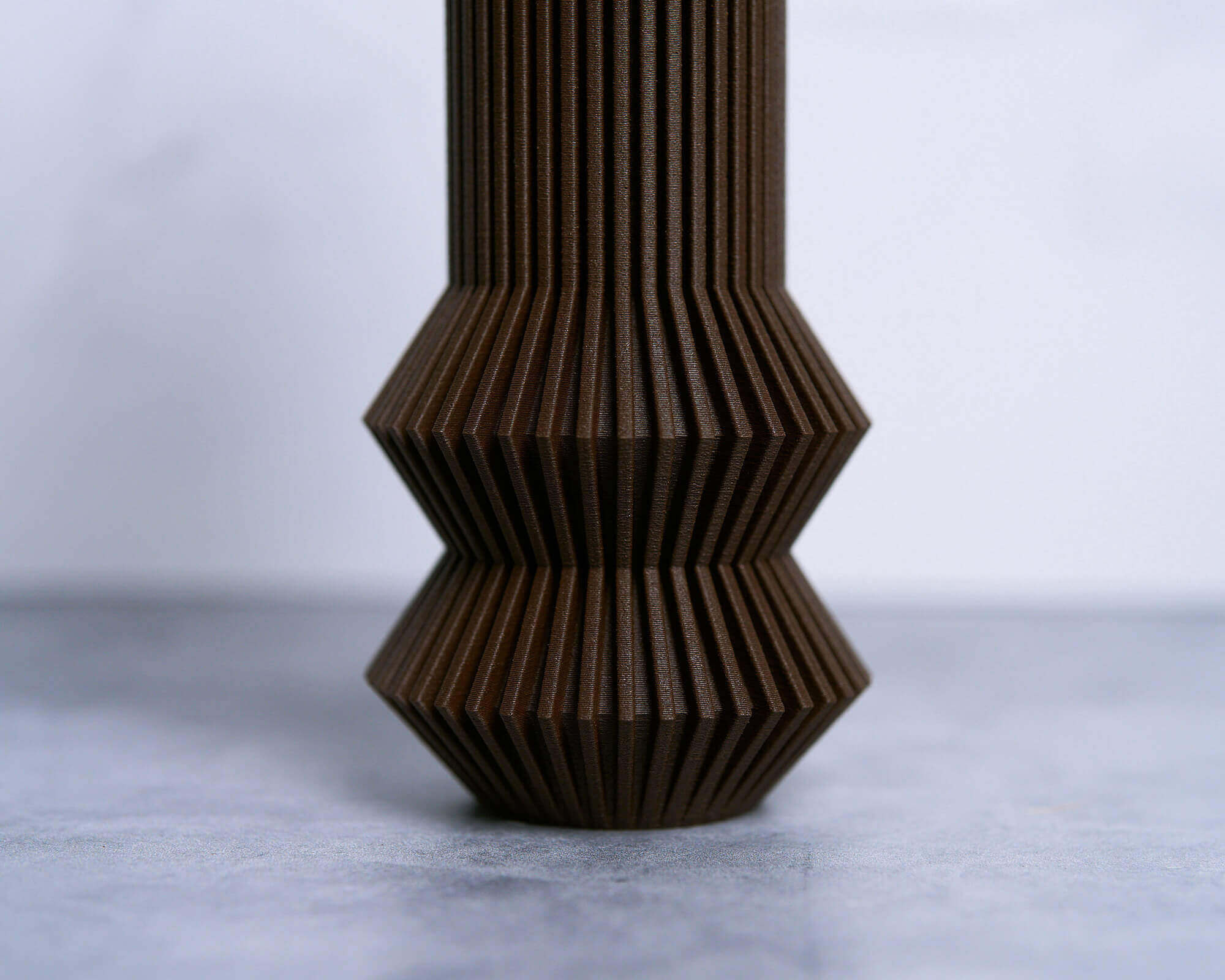 A zoomed in photo of an abstract vase. This is one of Woodland Pulse's unique vases. This is a brown vase.