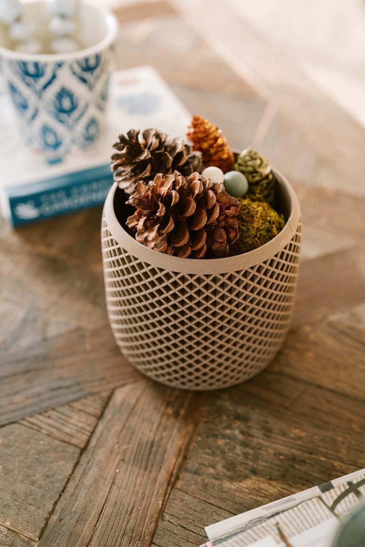 Modern planters | Unique Planters | Decor Planters, Woodland Pulse. A decor planter with pinecones inside on a coffee table.