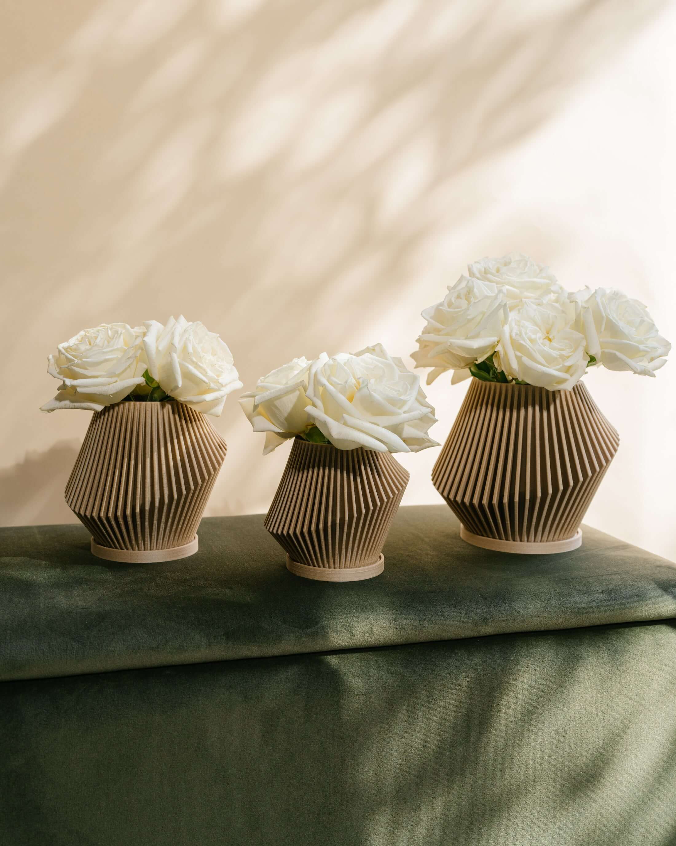 Set of three cream color planters with white roses.