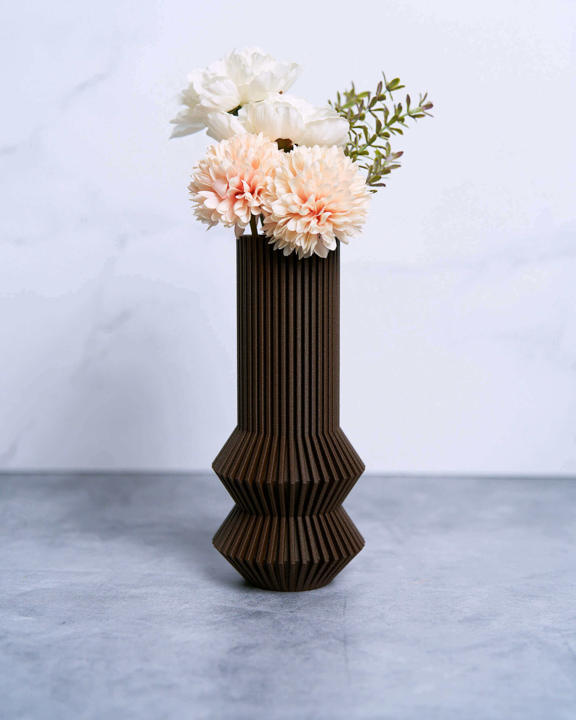 A mid century modern vase by Woodland Pulse. This is a brown vase with pink flowers inside from the modern vases collection.
