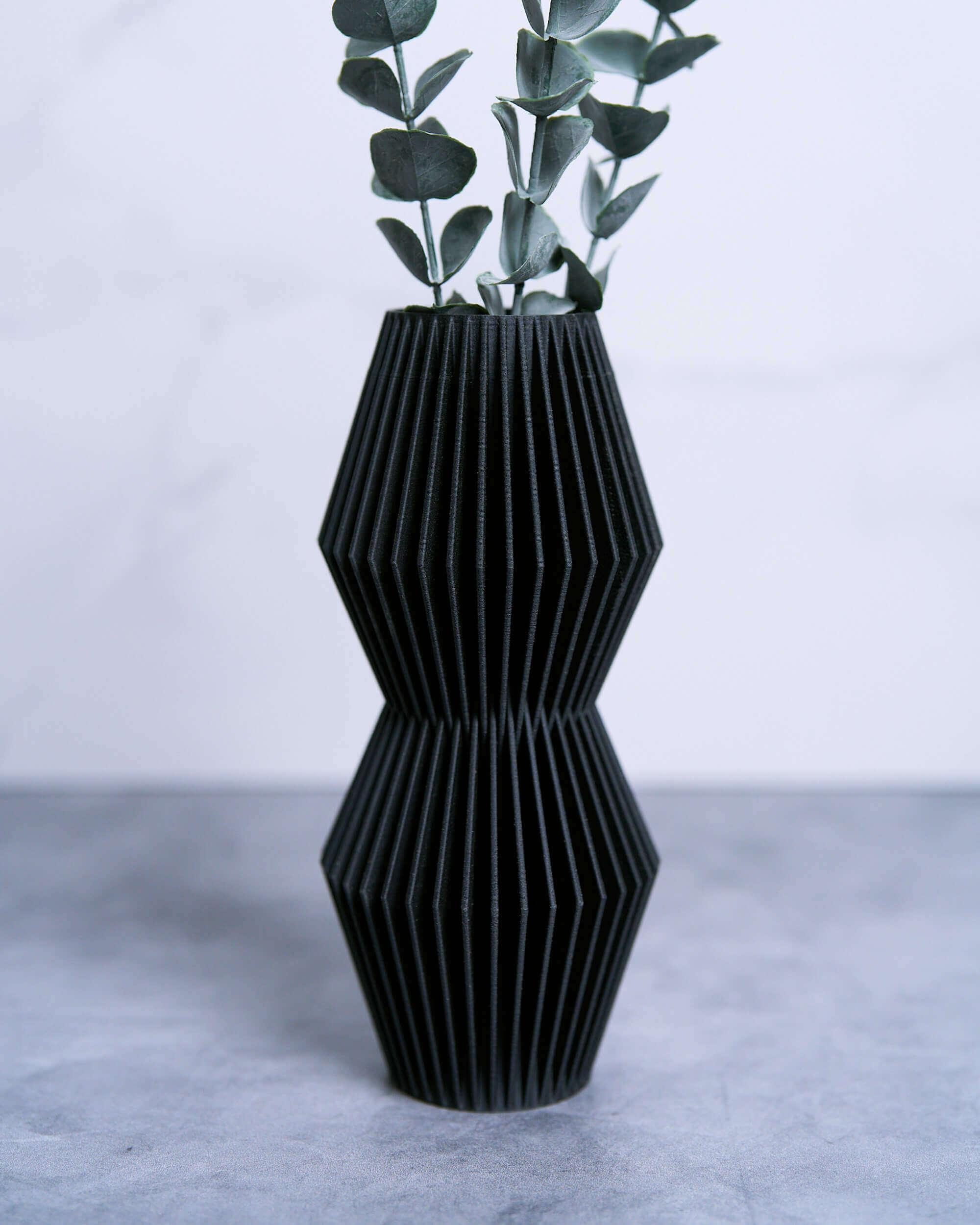 Black geometric vase LUNA with eucalyptus.