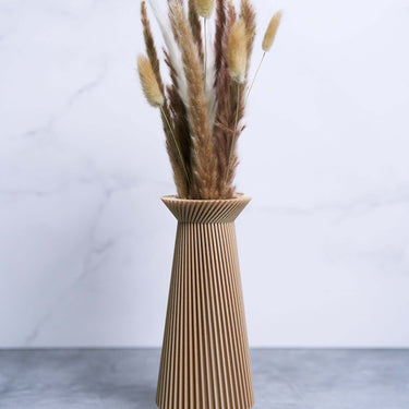 A beige vase with pampas grass by Woodland Pulse. This is a modernist vase from their boho vases collection.