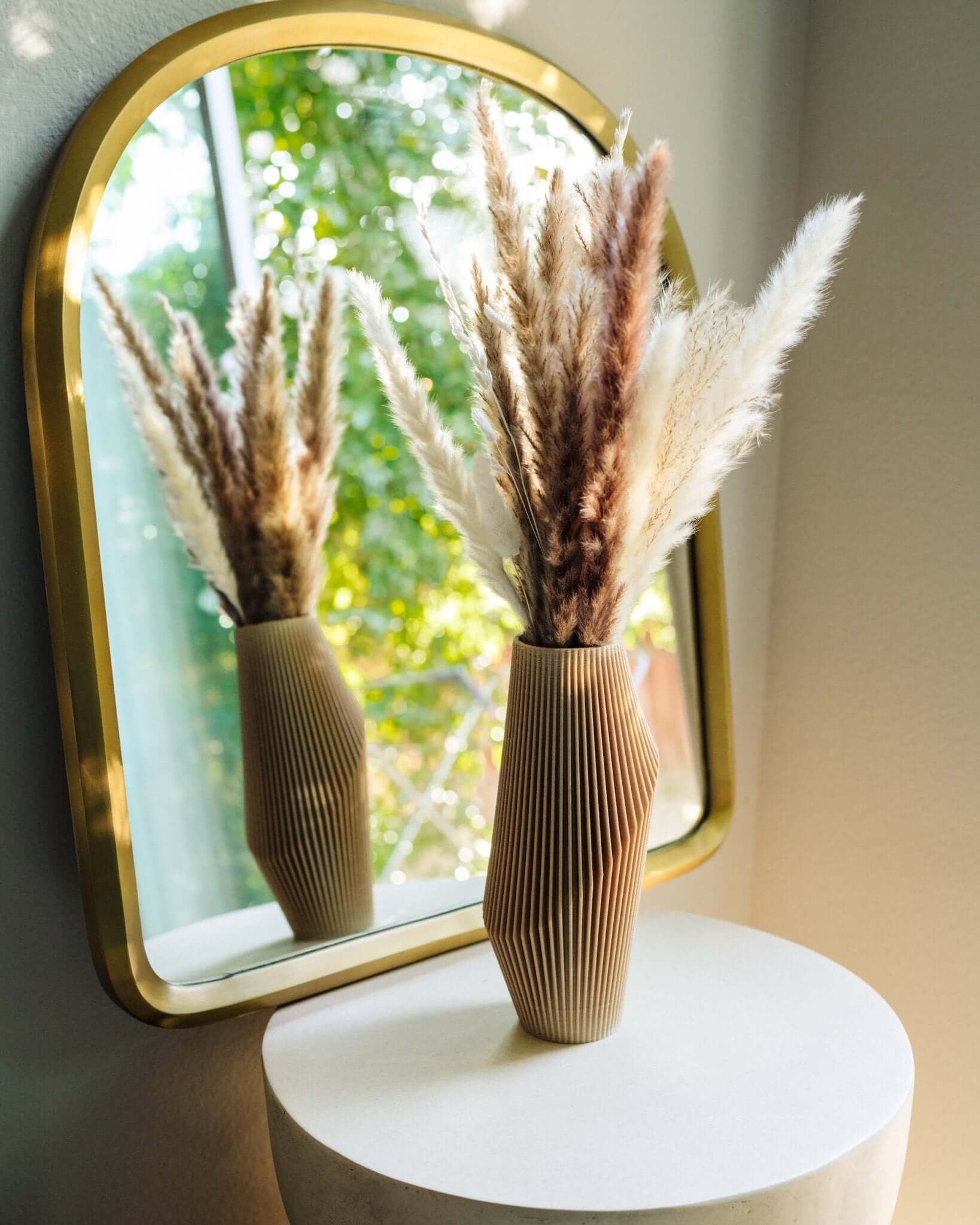 Beige vase with pampas grass decor in front of mirror