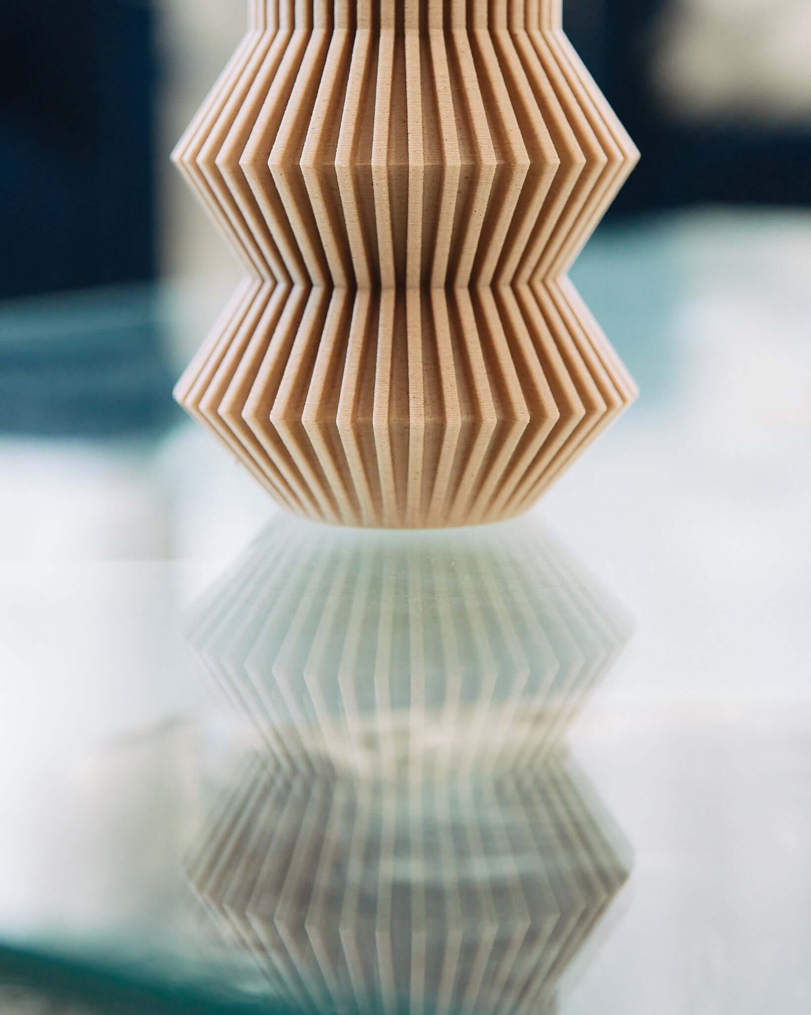 This is a picture of a part of one of Woodland Pulse's unique vases. It is a cream color vase with an abstract vase design.