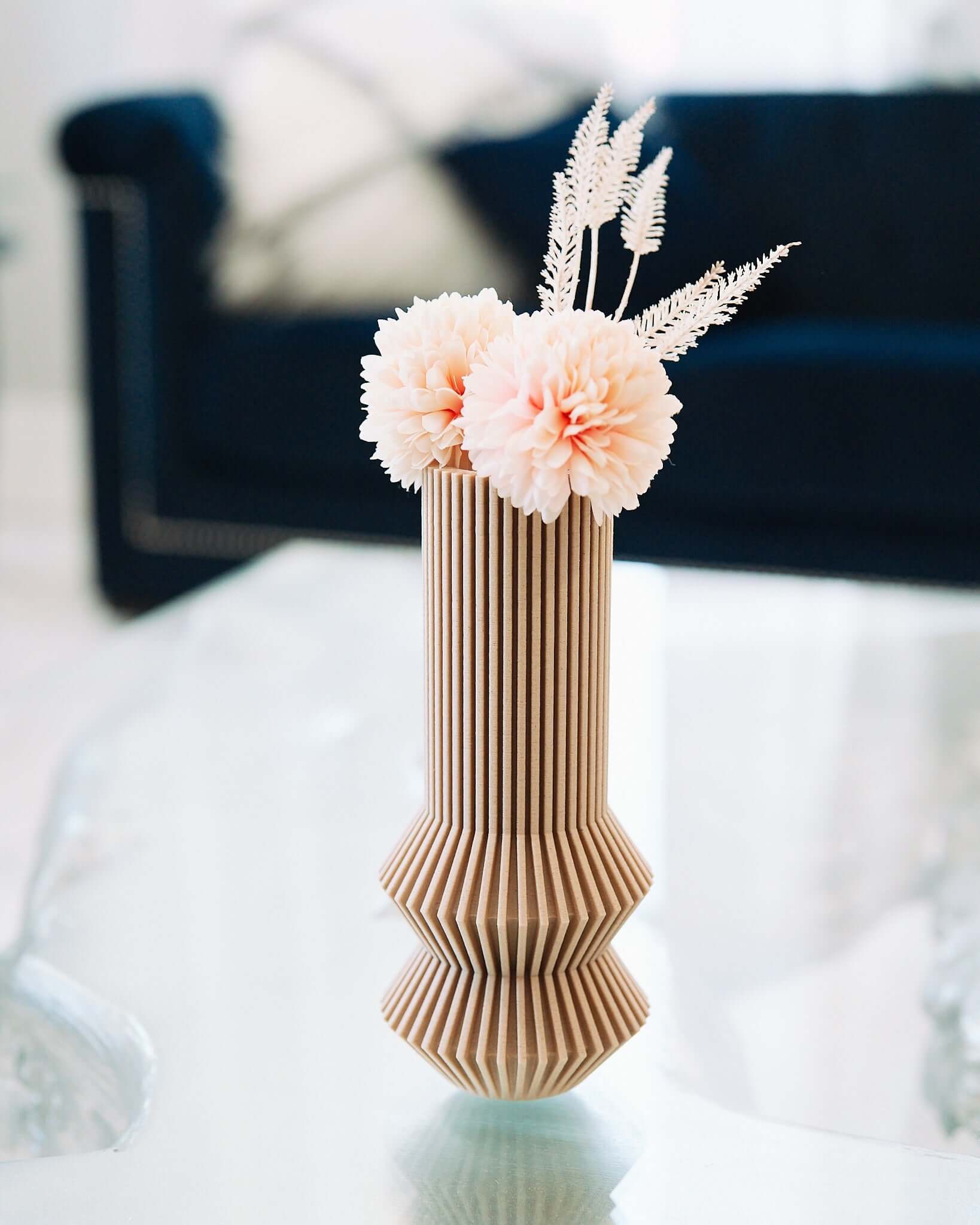 This is a cream color vase with pink flowers.
